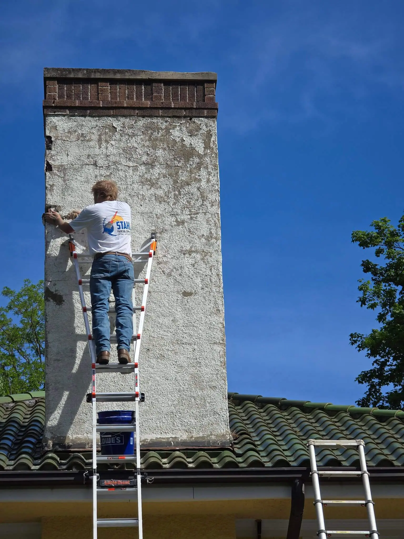 Stahl Painting Company's skilled team performing detailed exterior masonry and trim painting on a residential property.