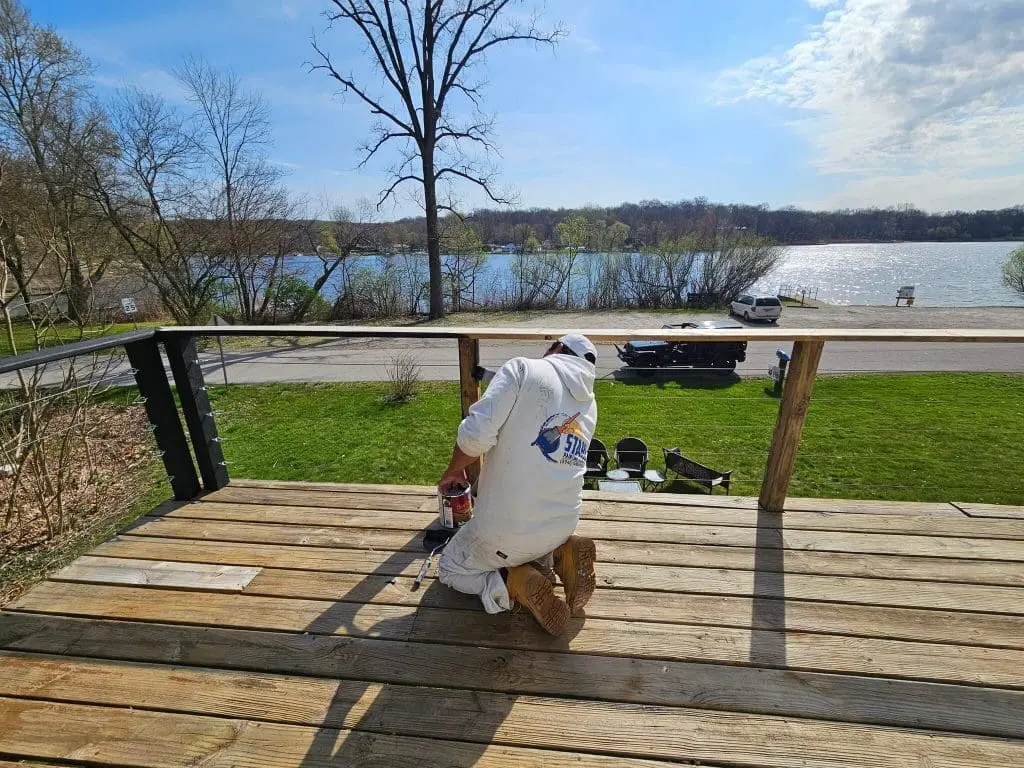 Stahl Painting Company's team member performing precision exterior deck maintenance and wood finishing.
