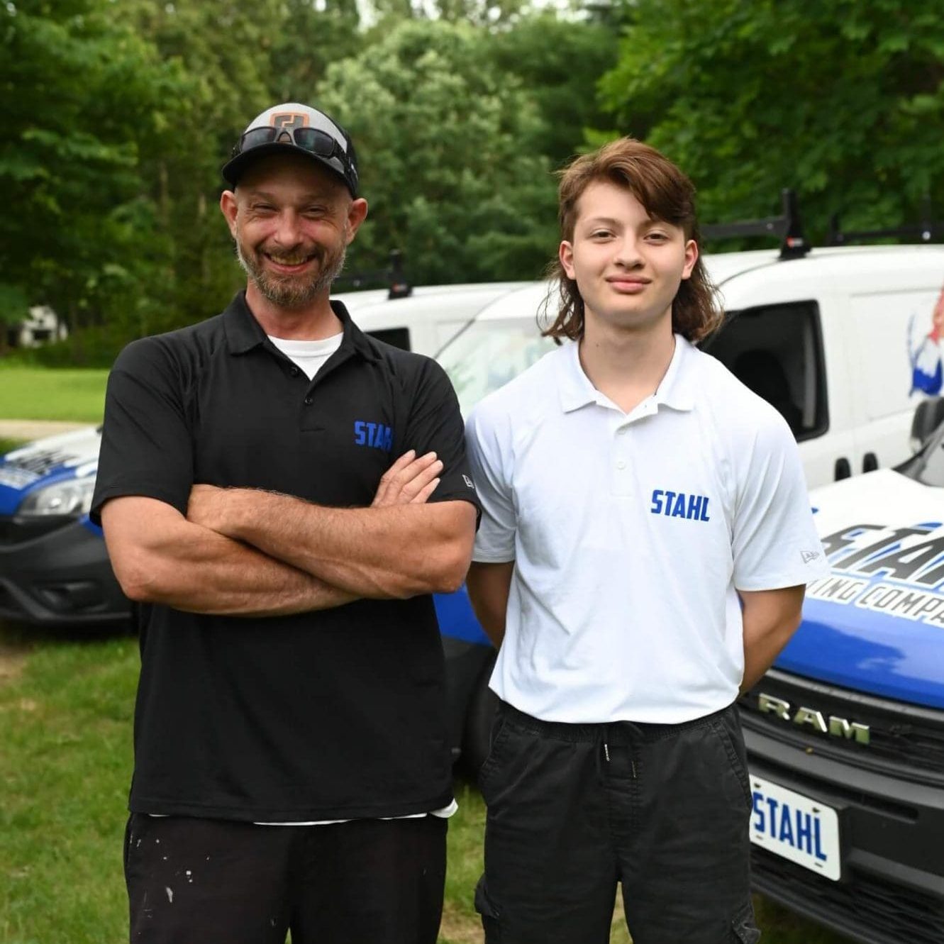 stahl painting team standing in front of branded vehicles