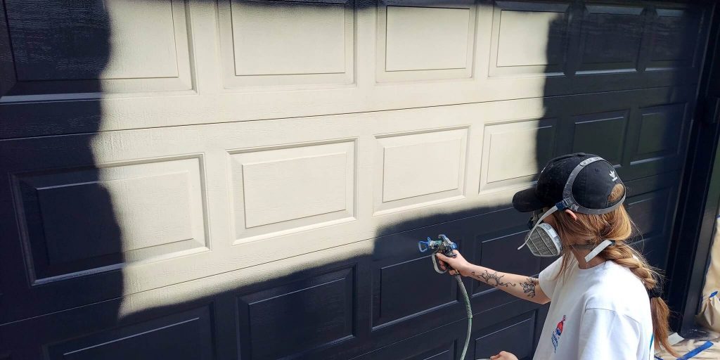 Stahl Painting Company's precision exterior restoration: expert application of high-quality paint on residential garage doors.