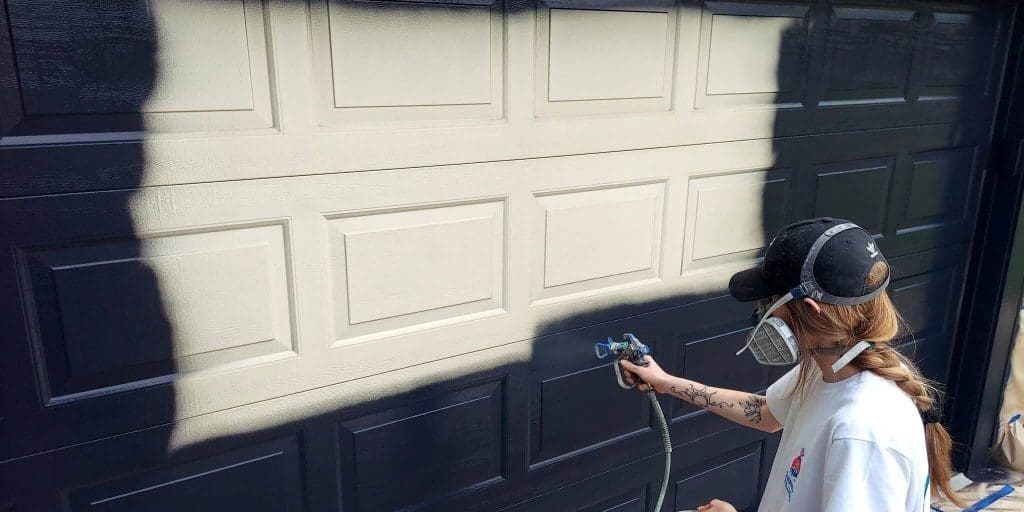 Stahl Painting Company's precision exterior restoration: expert application of high-quality paint on residential garage doors.